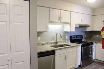 A kitchen with white cabinets and a black stove top oven